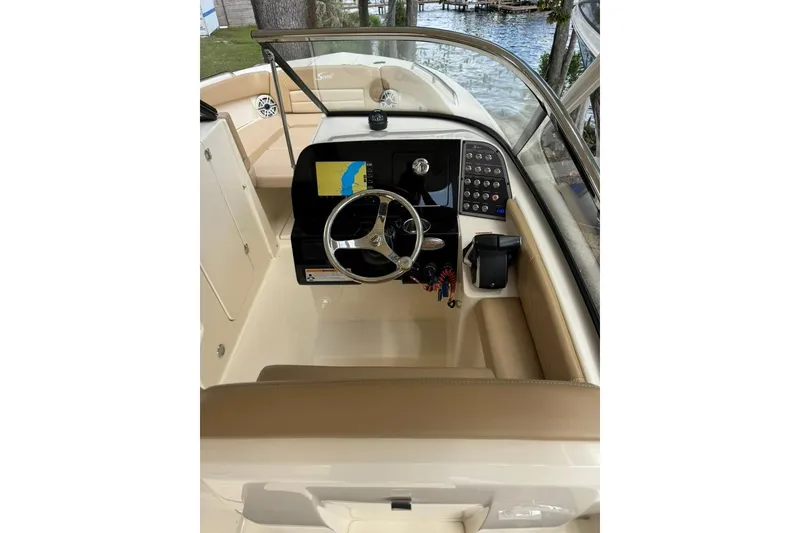 Slide: The Image of 2024 Scout 255 Dorado boat cockpit with steering wheel and navigation display. - 28