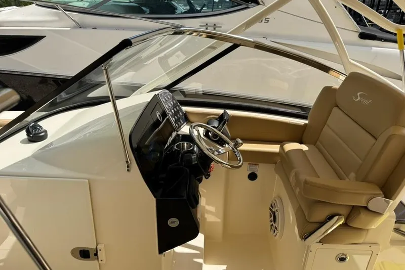 Slide: The Image of 2024 Scout 255 Dorado boat interior with steering wheel and beige seating. - 38