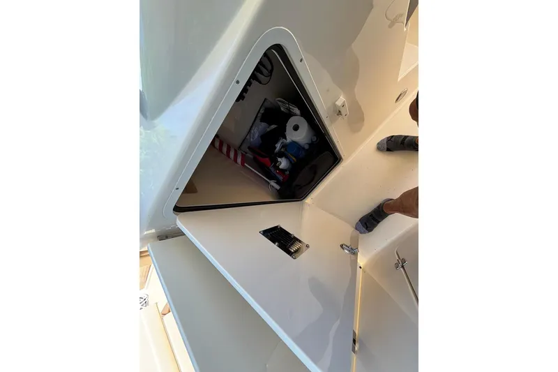 Slide: The Image of Open storage compartment on 2024 Scout 255 Dorado boat, showing various items inside. - 43
