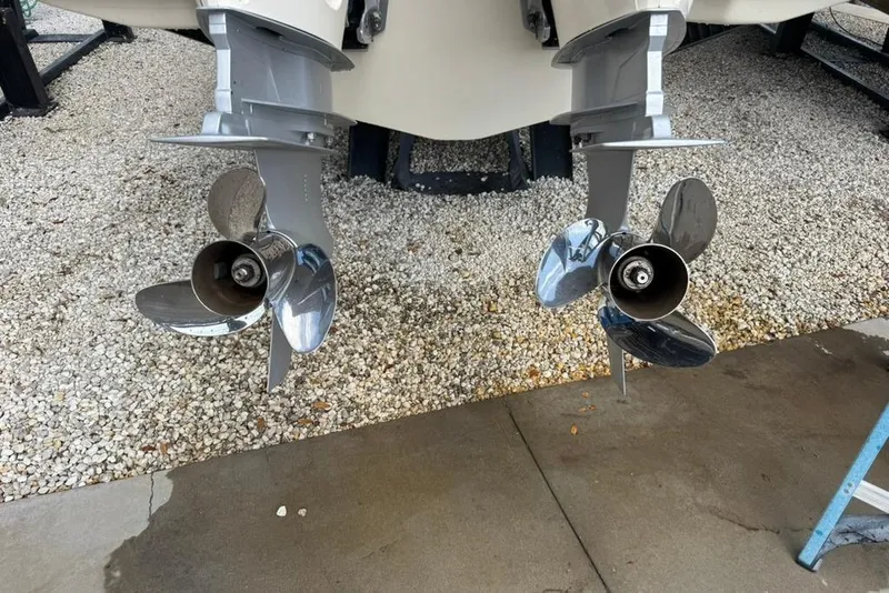 Slide: The Image of Twin propellers of a 2024 Scout 255 Dorado boat on gravel surface. - 47