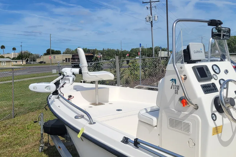 Slide: The Image of 2013 Key West 172 SE boat with Garmin navigation, parked near a fence under a clear sky. - 2