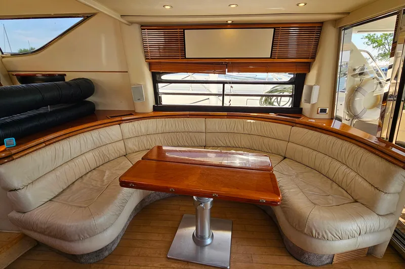 Slide: The Image of Luxurious interior of 1998 Sunseeker Manhattan 62 yacht with curved seating and wooden table. - 14