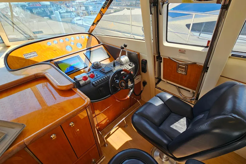 Slide: The Image of Luxurious helm of 1998 Sunseeker Manhattan 62 yacht with leather chair and navigation controls. - 22