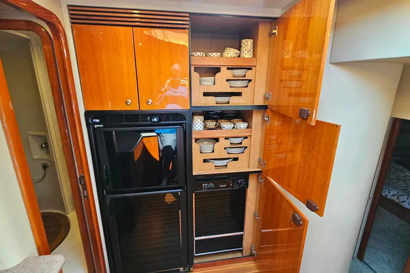 Slide: The Image of Kitchen area of 1998 Sunseeker Manhattan 62 yacht with wooden cabinets and appliances. - 33