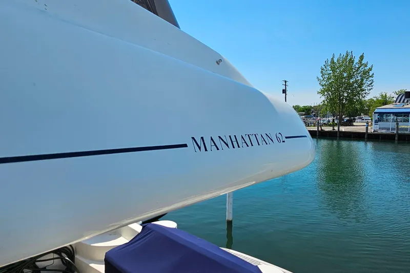 Slide: The Image of Sunseeker Manhattan 62 yacht docked by a serene waterfront, 1998 model. - 5
