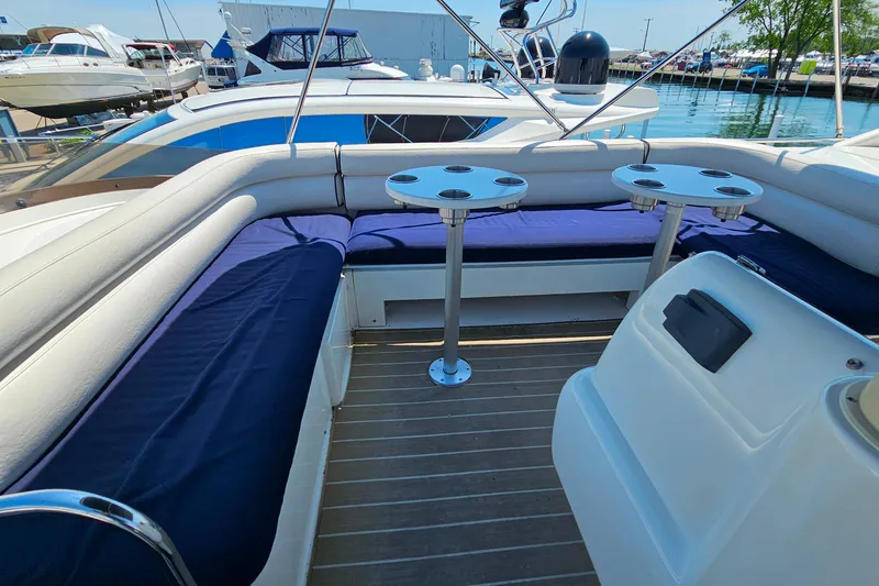 Slide: The Image of Luxurious seating area on a 1998 Sunseeker Manhattan 62 yacht, docked at a marina. - 52