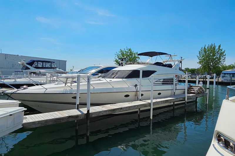 Slide: The Image of 1998 Sunseeker Manhattan 62 yacht docked at marina under clear blue sky. - 60