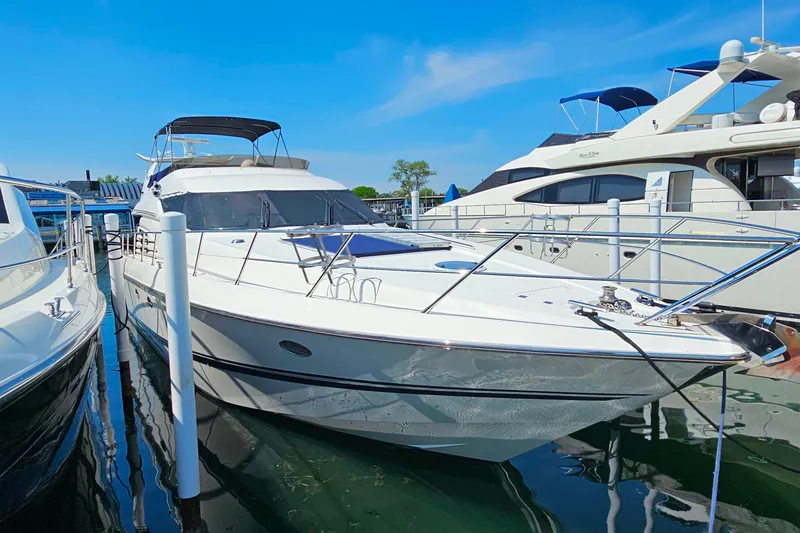 Slide: The Image of 1998 Sunseeker Manhattan 62 yacht docked at marina under clear blue sky. - 61