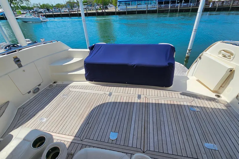 Slide: The Image of Sunseeker Manhattan 62 yacht deck, 1998 model, with covered seating and waterfront view. - 8
