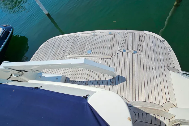 Slide: The Image of Sunseeker Manhattan 62 yacht deck, 1998 model, with wooden finish and water backdrop. - 9