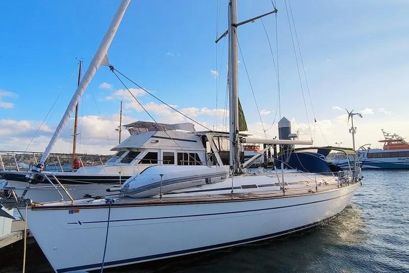 The Image of Sailboat Bavaria 49, 2003 model, docked at marina under clear blue sky. - 0
