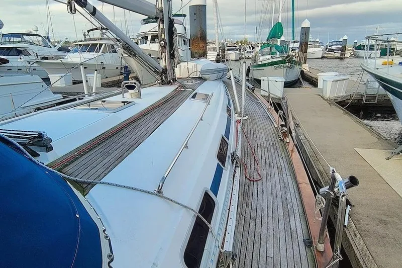 Slide: The Image of 2003 Bavaria 49 sailboat docked at marina, surrounded by other boats. - 11