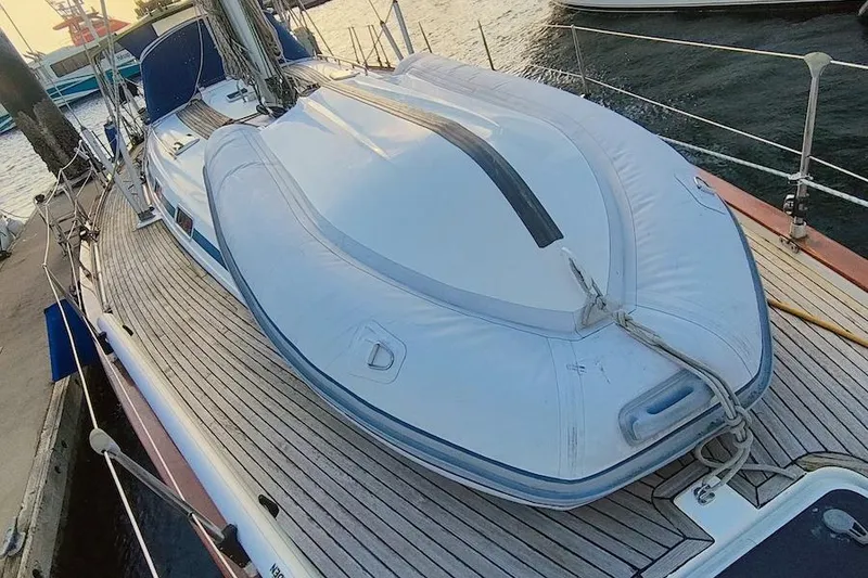 Slide: The Image of 2003 Bavaria 49 yacht with inflatable dinghy on deck, docked at marina. - 12