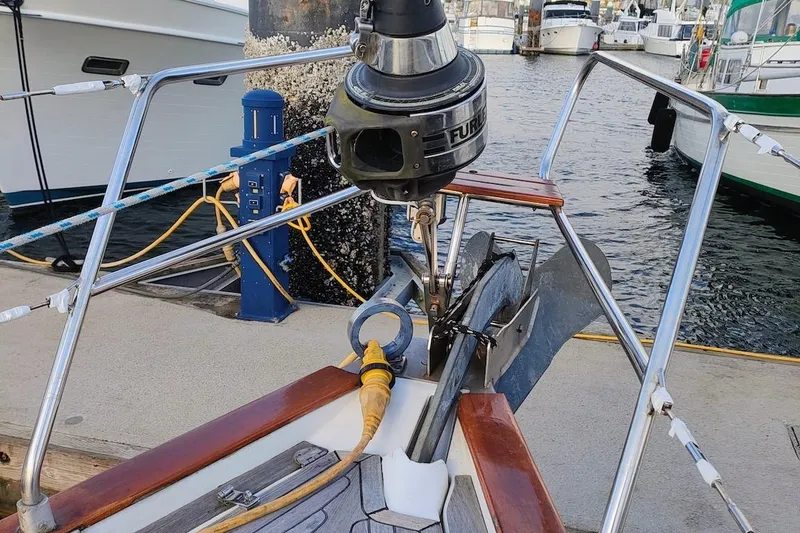 Slide: The Image of Bow of a 2003 Bavaria 49 yacht docked at a marina, featuring anchor and mooring lines. - 13