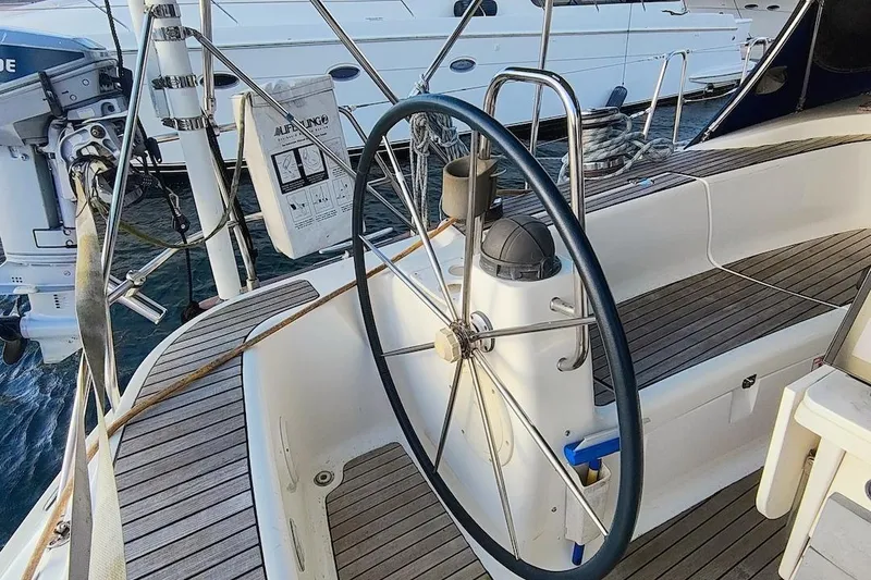 Slide: The Image of Steering wheel of a 2003 Bavaria 49 yacht with wooden deck details. - 16