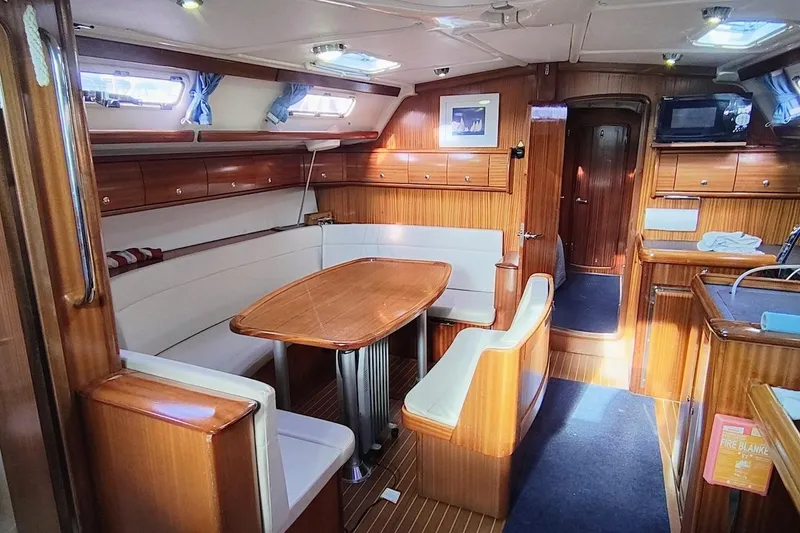 Slide: The Image of Interior of a 2003 Bavaria 49 yacht with wooden furnishings and dining area. - 18