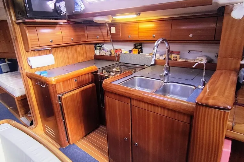 Slide: The Image of Luxurious wooden kitchen interior of a 2003 Bavaria 49 yacht, featuring modern amenities. - 22