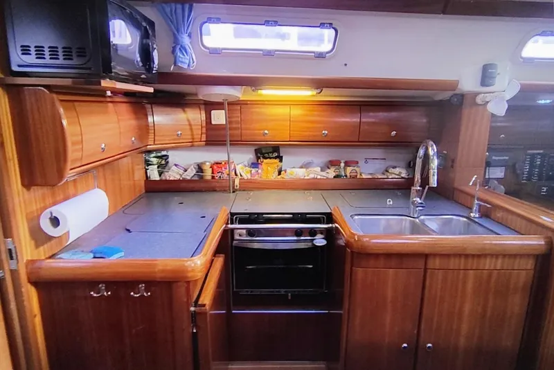 Slide: The Image of Galley kitchen in 2003 Bavaria 49 yacht with wooden cabinetry and modern appliances. - 23