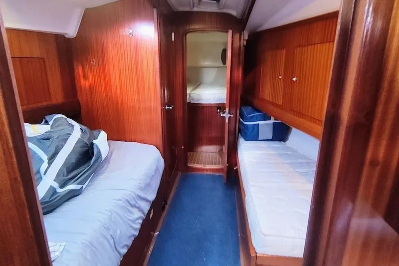 Slide: The Image of Interior cabin of 2003 Bavaria 49 yacht with wooden paneling and cozy beds. - 25