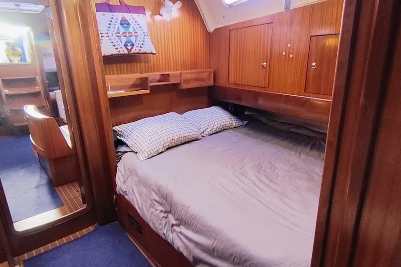 Slide: The Image of Cozy cabin interior of 2003 Bavaria 49 yacht with wooden paneling and comfortable bedding. - 26