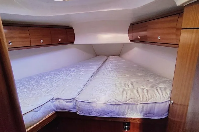 Slide: The Image of Cozy cabin interior of 2003 Bavaria 49 yacht with twin beds and wooden storage cabinets. - 27