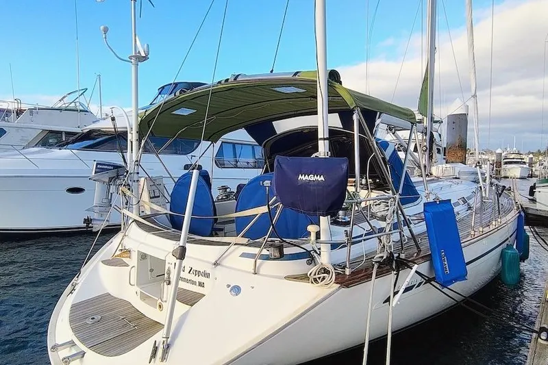 Slide: The Image of 2003 Bavaria 49 sailboat docked at marina, featuring green canopy and blue accessories. - 5