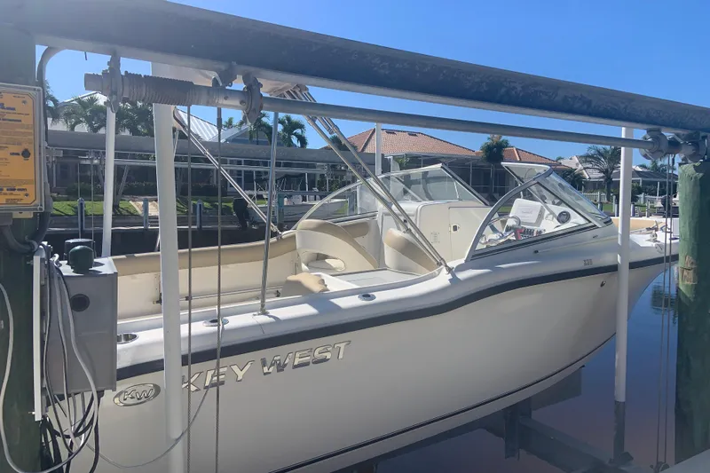 The Image of 2016 Key West 239 DFS boat on lift, docked near waterfront homes. - 0