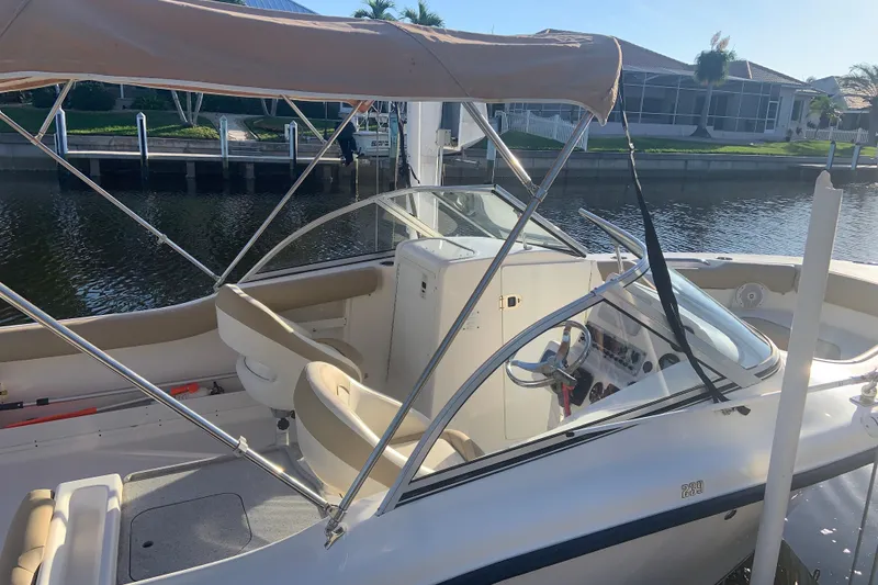 Slide: The Image of 2016 Key West 239 DFS boat docked by a canal, featuring a spacious interior. - 1