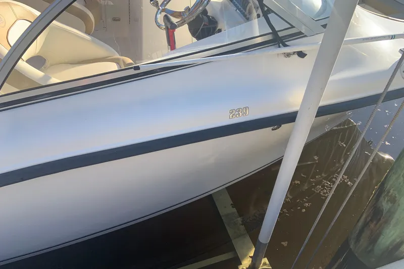 Slide: The Image of 2016 Key West 239 DFS boat docked, showing side view and interior seating. - 16