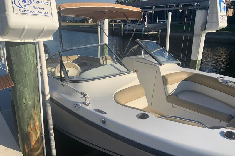 Slide: The Image of 2016 Key West 239 DFS boat docked, featuring beige seating and a canopy. - 2