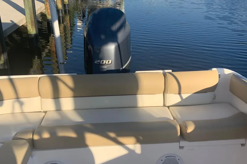 Slide: The Image of 2016 Key West 239 DFS boat with Yamaha 200 engine, beige seating, docked on calm water. - 22