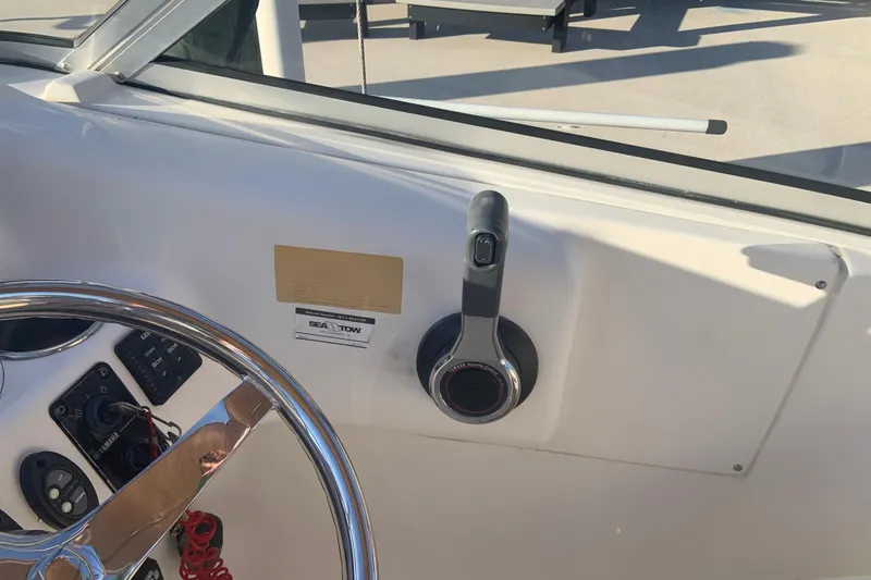 Slide: The Image of 2016 Key West 239 DFS boat helm with steering wheel and throttle controls. - 28