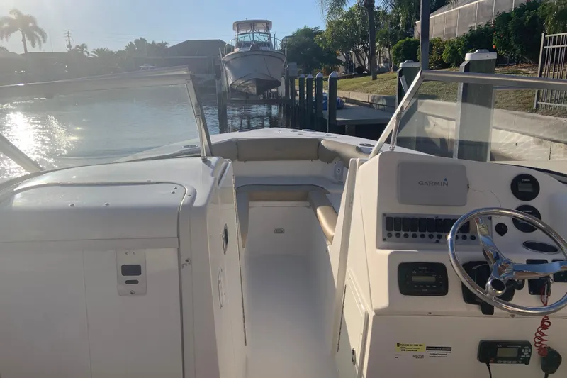 Slide: The Image of 2016 Key West 239 DFS boat interior with Garmin navigation, docked by a sunny canal. - 30