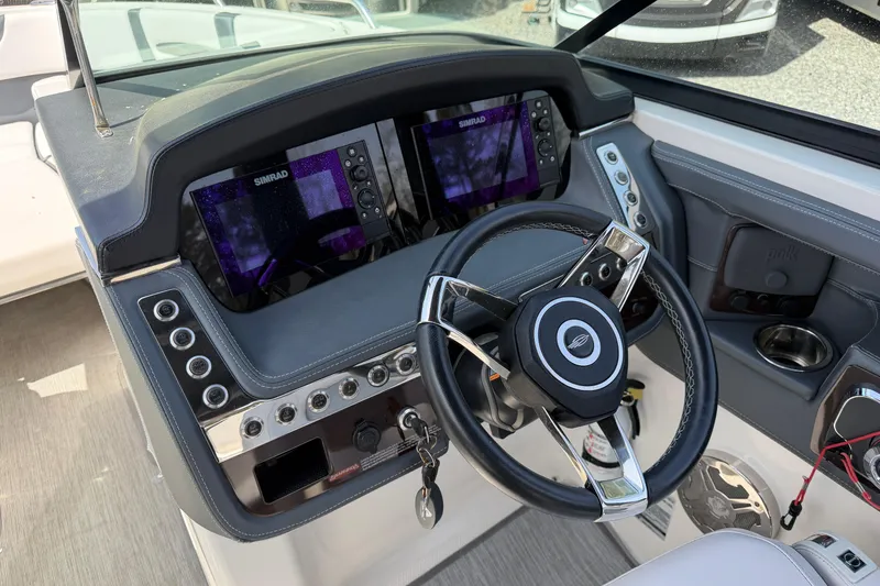 Slide: The Image of 2019 Chaparral 257 SSX boat dashboard with dual Simrad displays and steering wheel. - 10