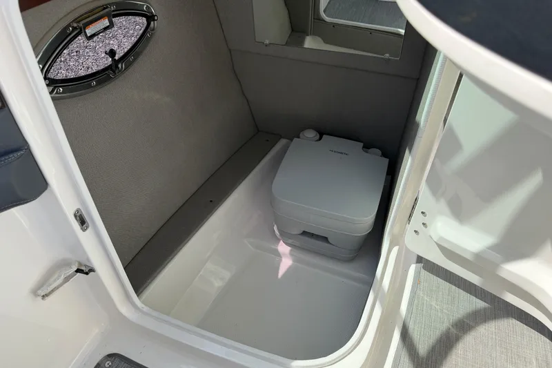 Slide: The Image of 2019 Chaparral 257 SSX boat interior with portable toilet and window. - 19