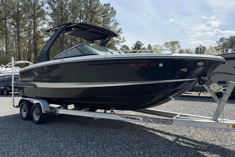 Slide: The Image of 2019 Chaparral 257 SSX boat on trailer at marina, surrounded by trees. - 4