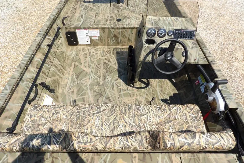 Slide: The Image of 2026 Crestliner 1760 Retriever SC boat interior with camouflage design and steering console. - 14