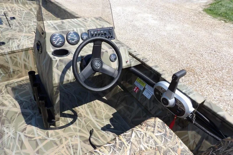 Slide: The Image of 2026 Crestliner 1760 Retriever SC boat interior with camouflage design and steering console. - 20