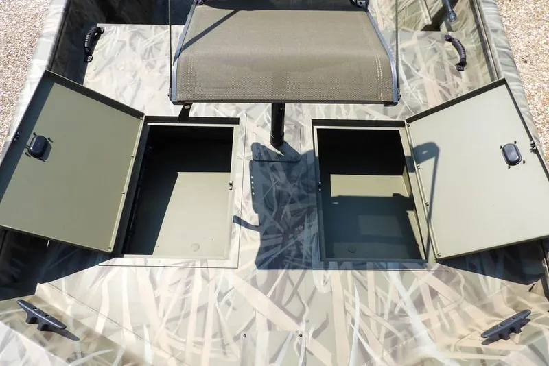 Slide: The Image of 2026 Crestliner 1760 Retriever SC boat with open storage compartments and camouflage design. - 25