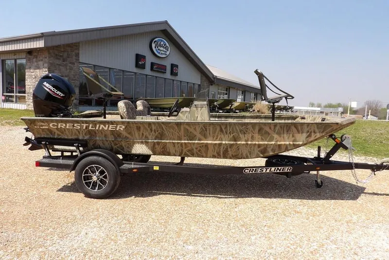 Slide: The Image of 2026 Crestliner 1760 Retriever SC boat on trailer, camo design, parked outside dealership. - 3