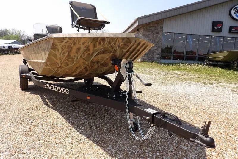 Slide: The Image of 2026 Crestliner 1760 Retriever SC boat on trailer, camo design, parked outside dealership. - 33