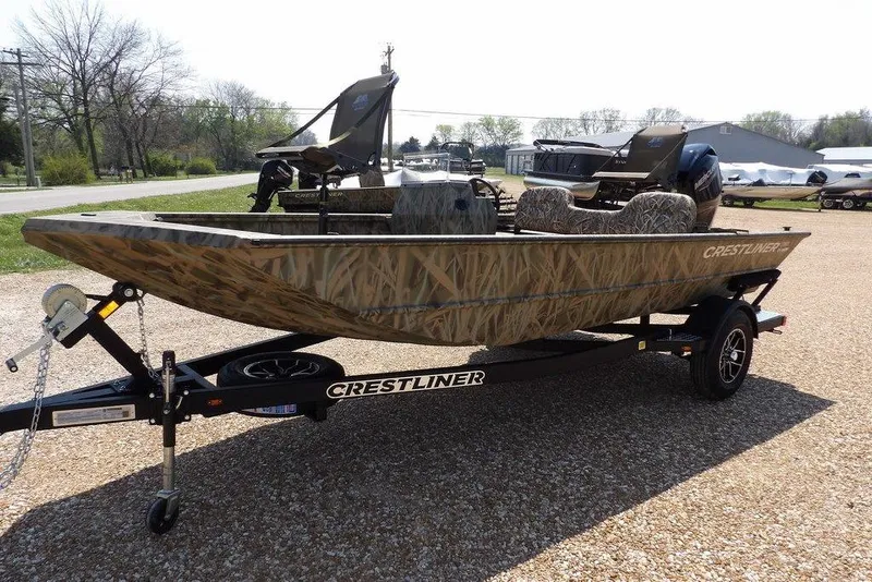 Slide: The Image of 2026 Crestliner 1760 Retriever SC boat on trailer, camo design, parked outdoors. - 4