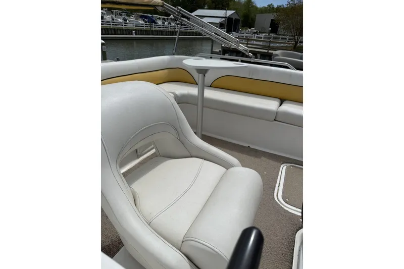 Slide: The Image of 2011 Hurricane SunDeck Sport 201 OB boat interior with white seating and yellow accents. - 6