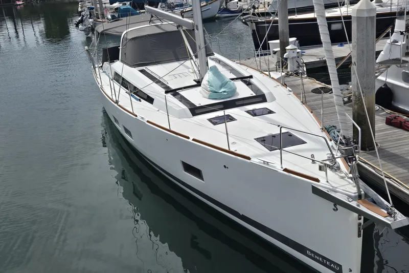 Slide: The Image of 2016 Beneteau Oceanis 55 sailboat docked in marina, sleek design, white hull. - 16