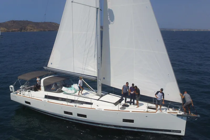 Slide: The Image of 2016 Beneteau Oceanis 55 sailing yacht with crew on deck in open water. - 2