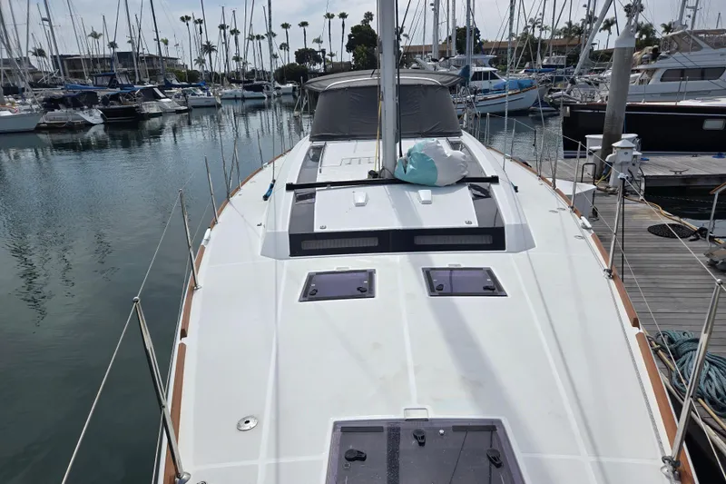 Slide: The Image of 2016 Beneteau Oceanis 55 sailboat docked in marina, showcasing sleek deck design. - 23