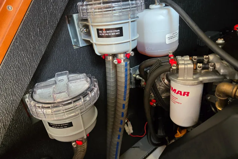 Slide: The Image of Engine compartment of a 2016 Beneteau Oceanis 55 yacht, featuring filters and hoses. - 29