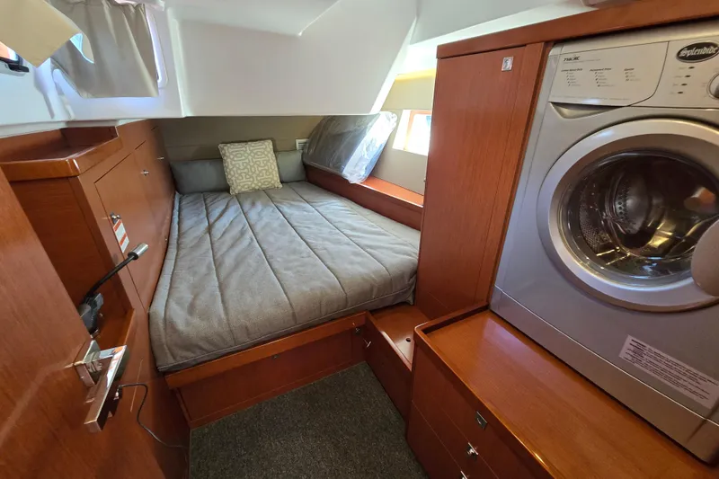 Slide: The Image of Cozy cabin interior of 2016 Beneteau Oceanis 55 with bed and washing machine. - 56
