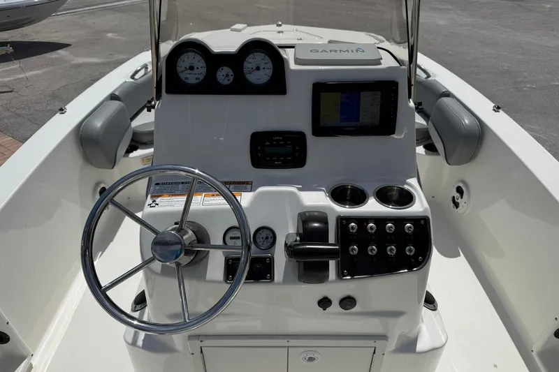 Slide: The Image of 2021 NauticStar 191 Hybrid boat dashboard with steering wheel, gauges, and Garmin navigation system. - 15