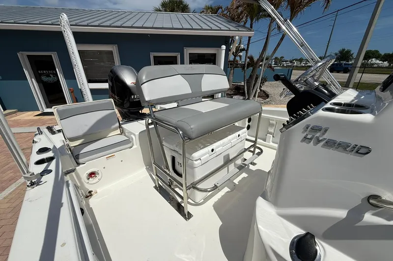 Slide: The Image of 2021 NauticStar 191 Hybrid boat interior with seating and console, parked outdoors. - 16